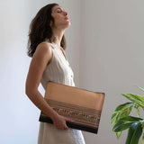 Greek leather portfolio inspired by Greek art depicting a geometrical period drawing of a chariot from Homers Iliad - with model holding it